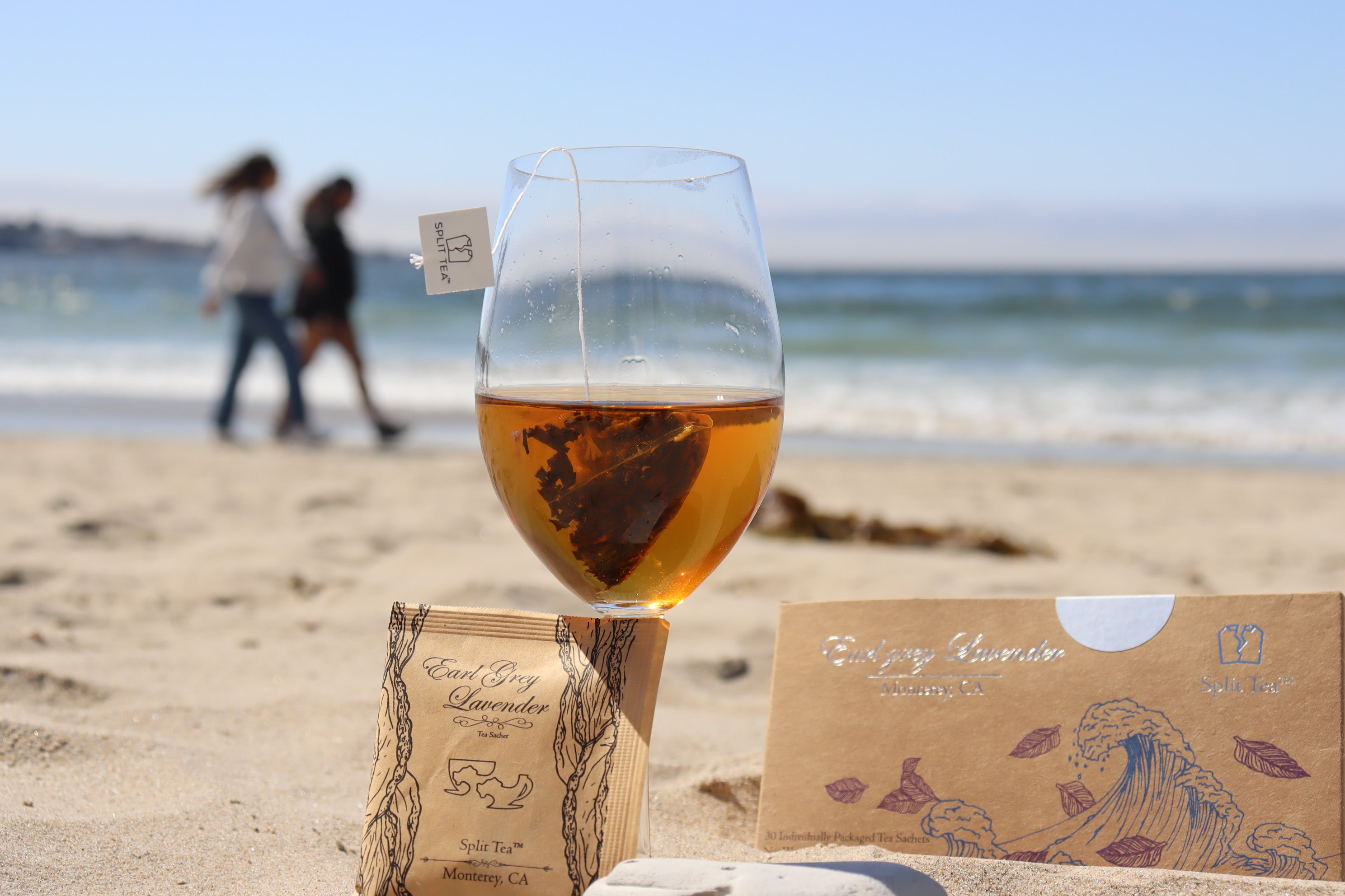 Glass of tea with a teabag on a beach monterey tea bags wholesale premium whole leaf tea Kraft bag pyramid tea bag Monterey California tea bags eco friendly loose leaf split tea tea at the beach restaurants boutique hotels spas brunch breakfast cafes